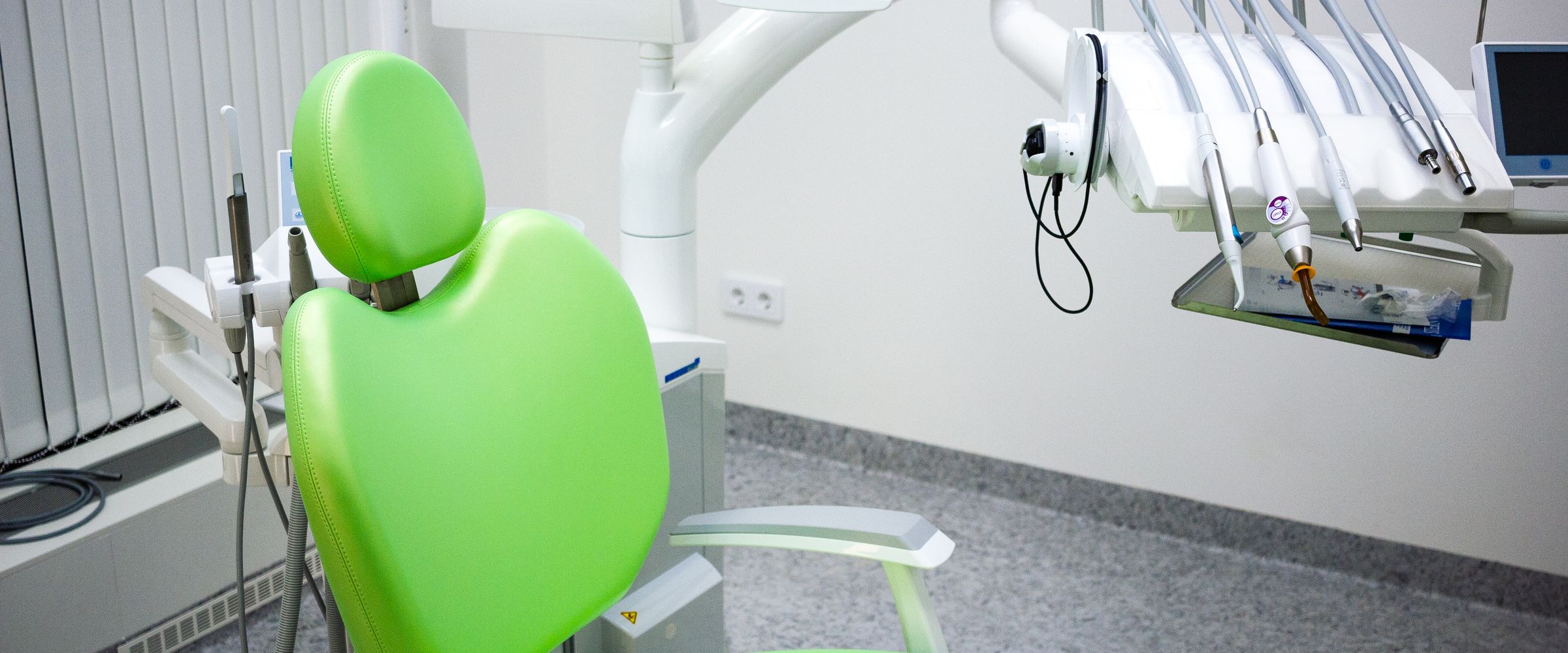 Grön behandlingsstol med monitor och instrument