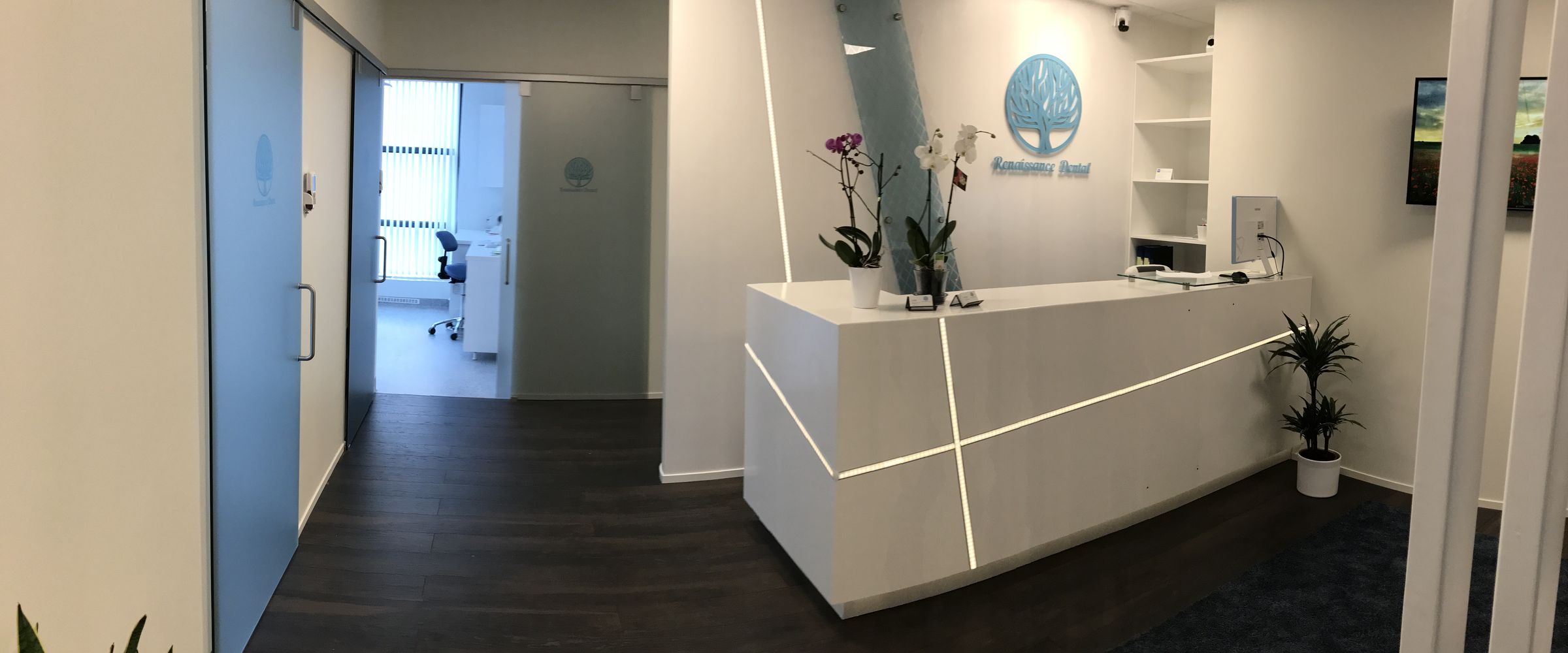 Receptionen på Renaissance Dental med vit disk och loggan på väggen